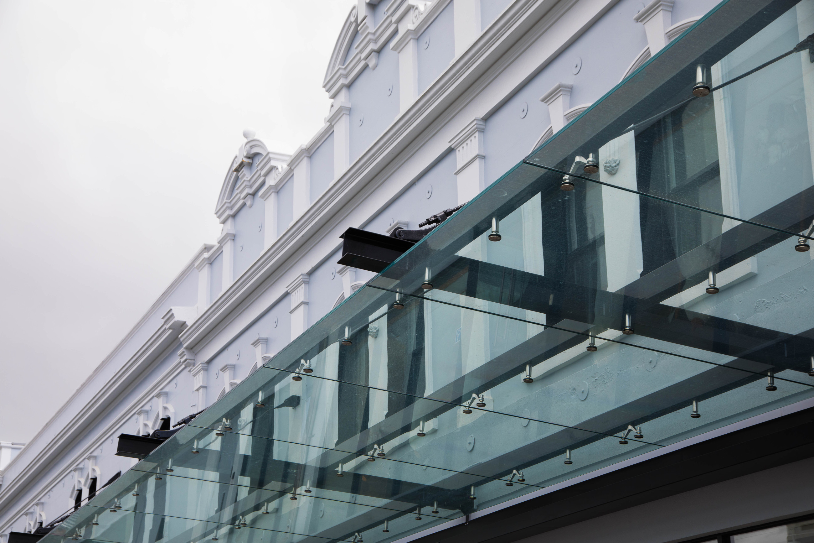 White architectural building adorned with a sleek glass canopy