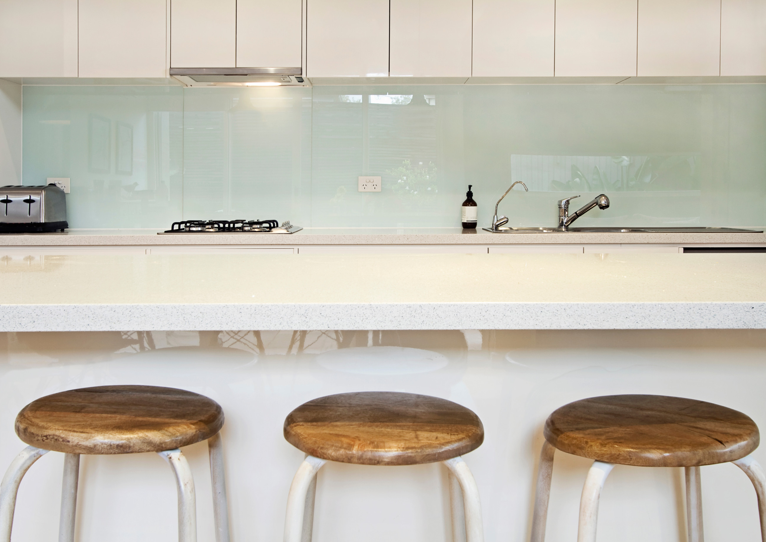 White kitchen with light green splash back