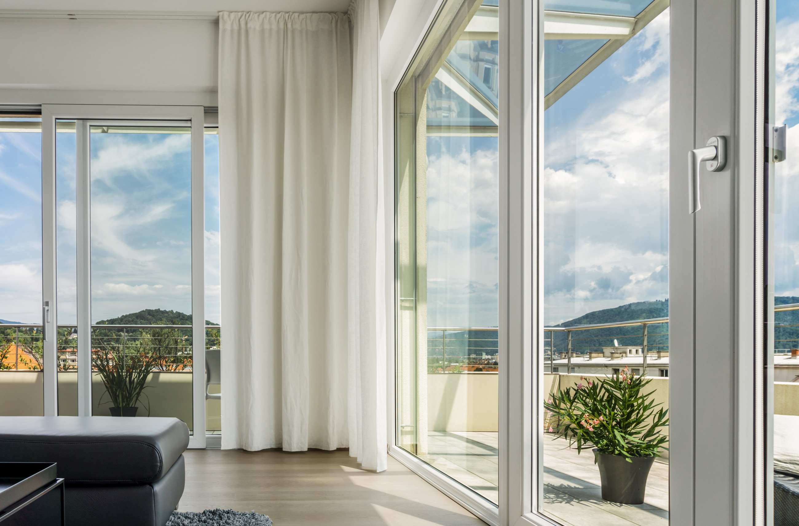 Spacious glass sliding doors opening to a panoramic hillside vista