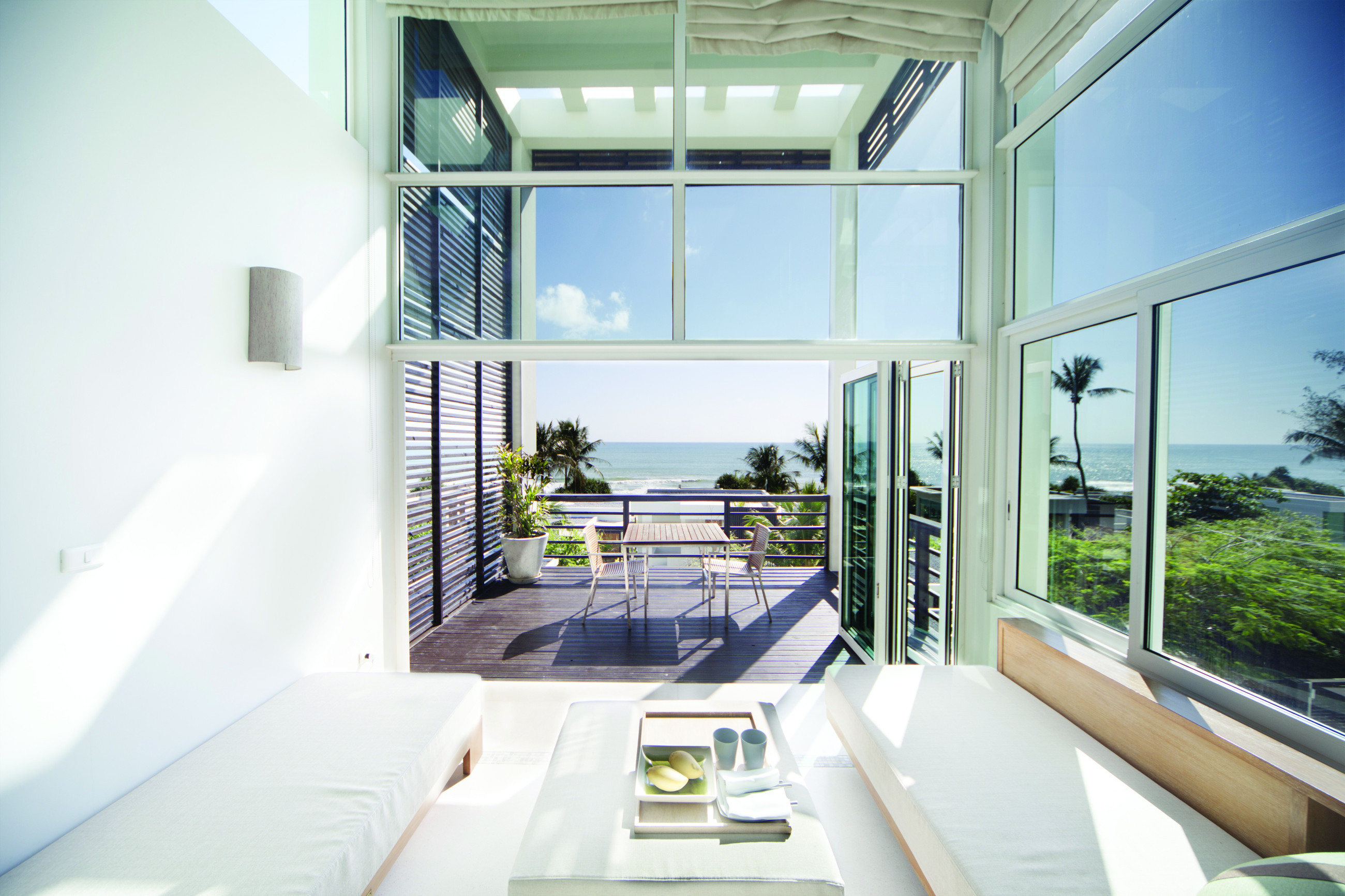 Spacious and breezy conservatory with ocean vistas and a white seating arrangement