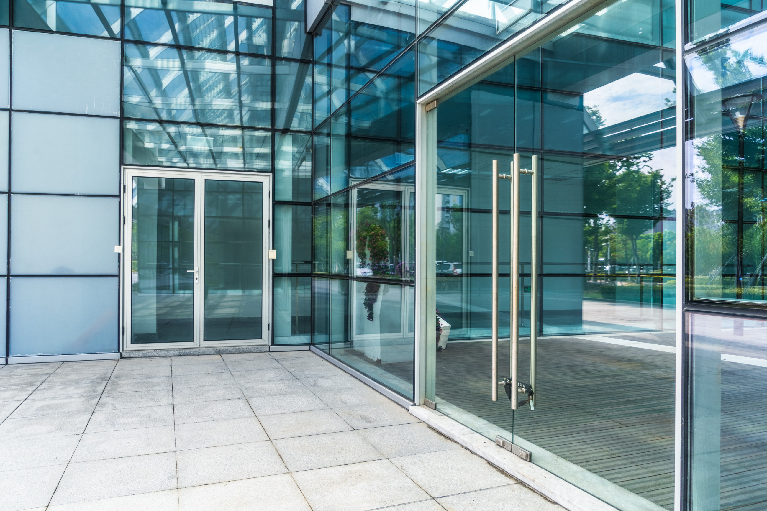 White commercial building featuring transparent glass entrance doors