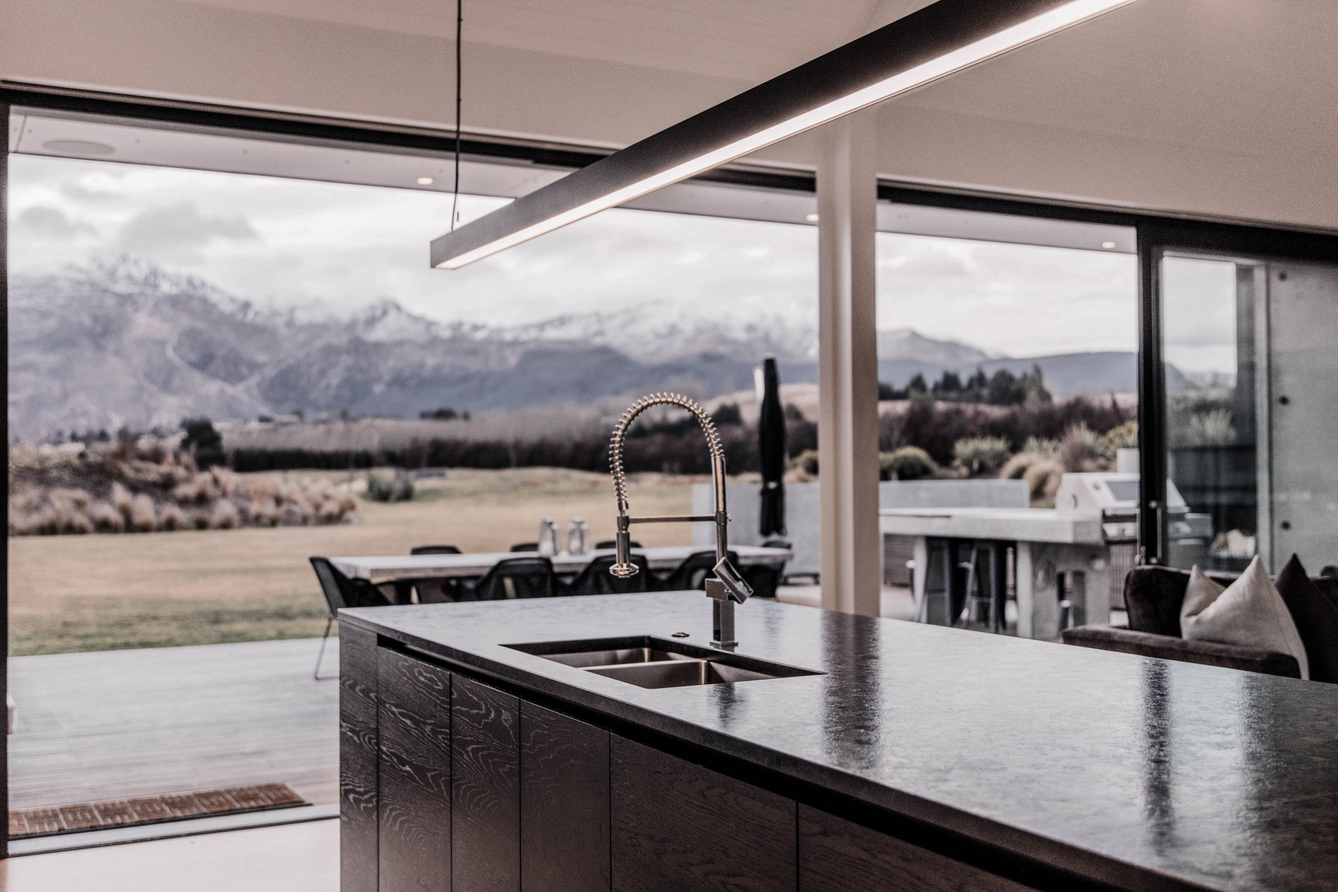 Elegant modern kitchen, with vast windows and doors offering views of distant mountains