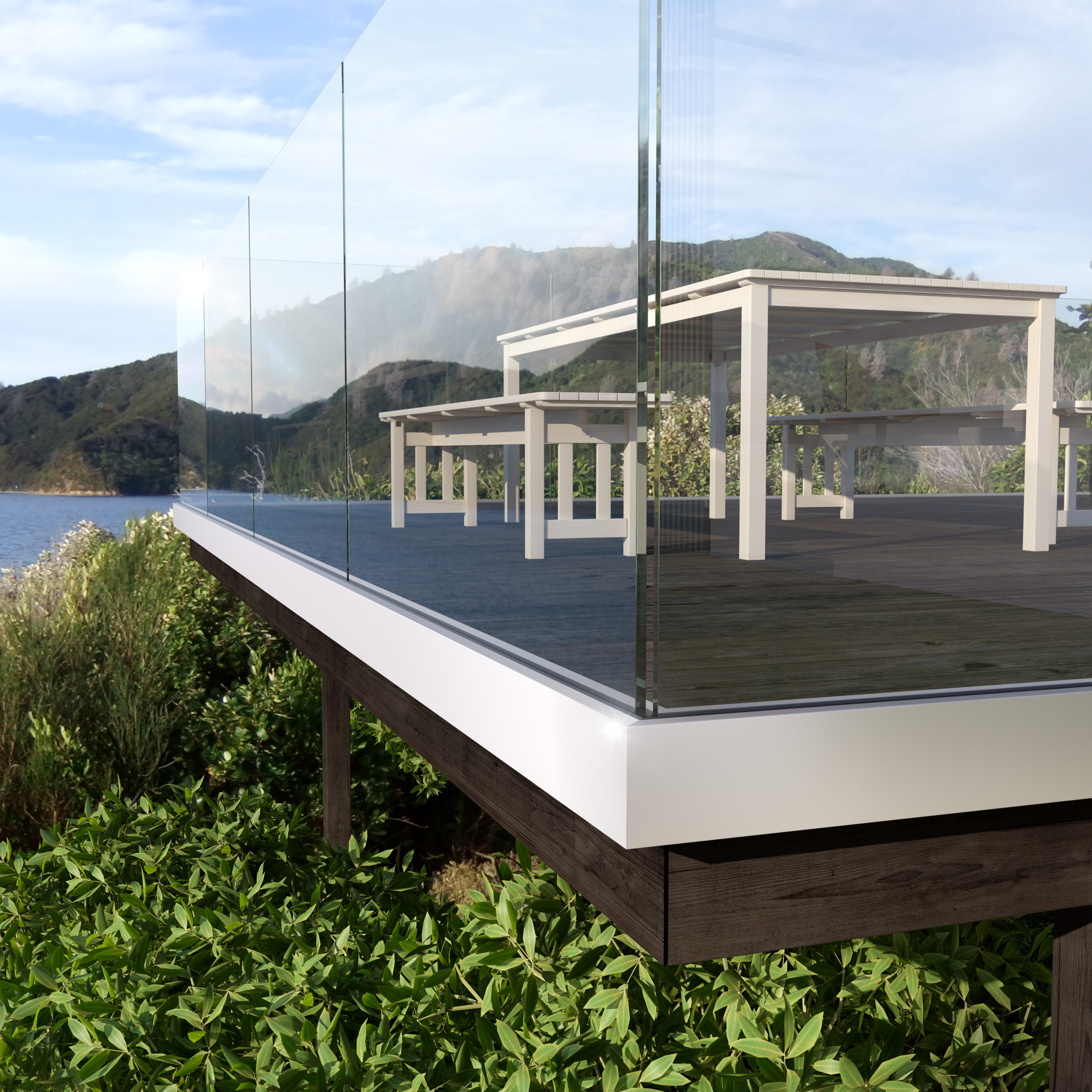 Glass balustrade with white seating area, offering views of a lush green bush and the ocean