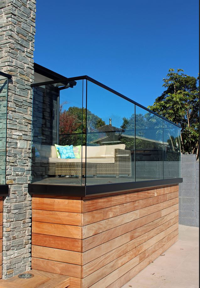 House with glass balustrade with timber and stone exterior