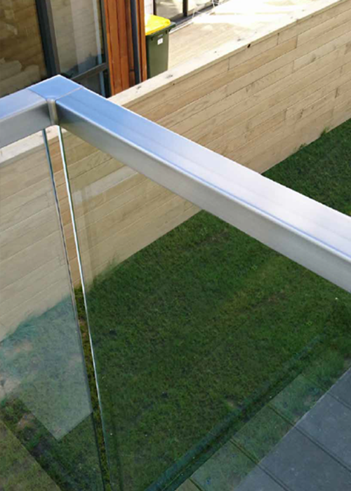 Glass balustrade with green grass