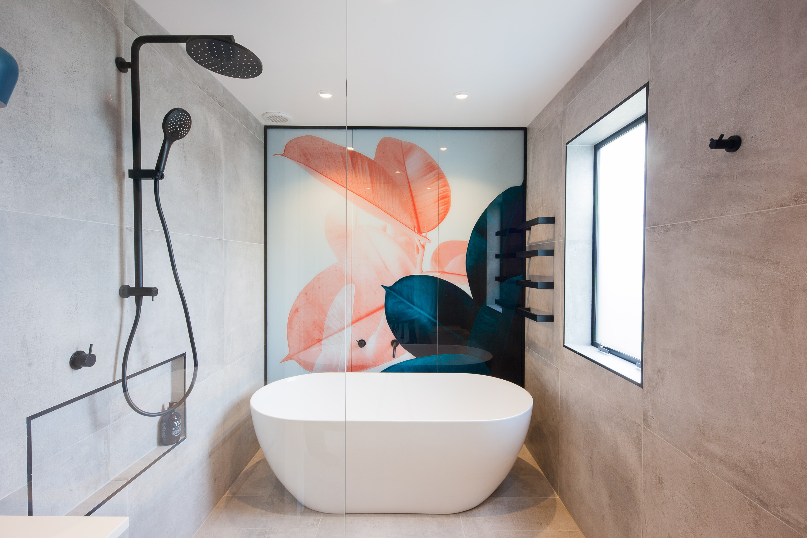 Glass shower screen with a bathtub and a digitally printed backdrop for aesthetic appeal
