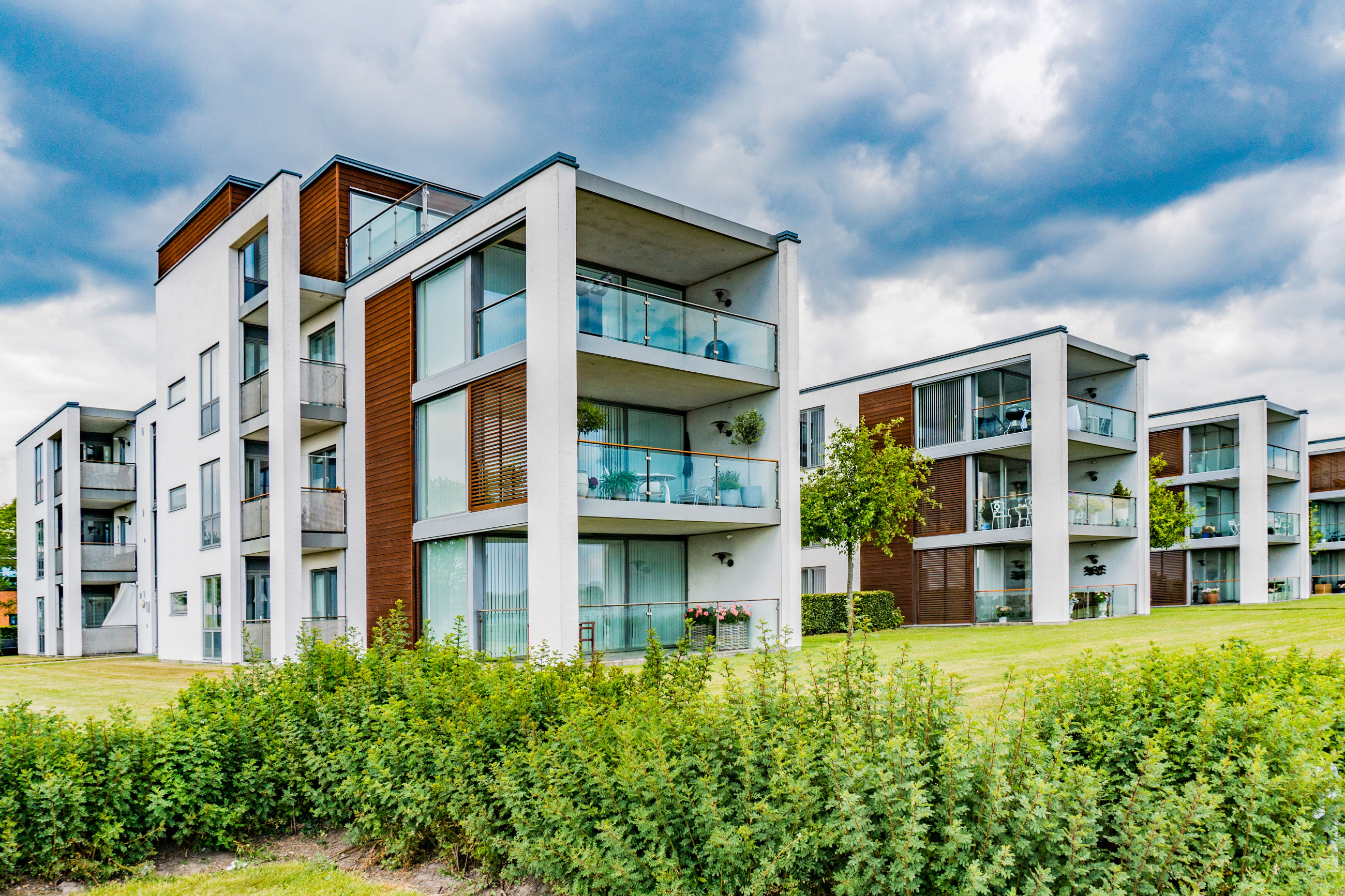 A modern apartment building with a sleek glass balustrade.