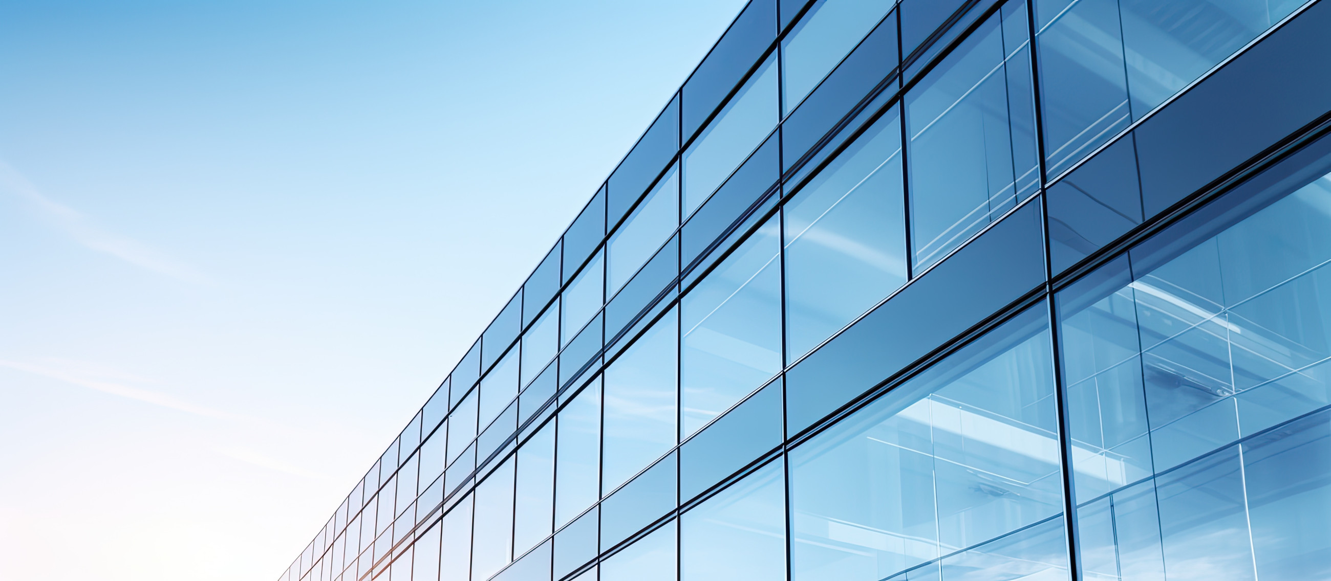 Glass-covered commercial building with double glazing reflecting the sky in the background.