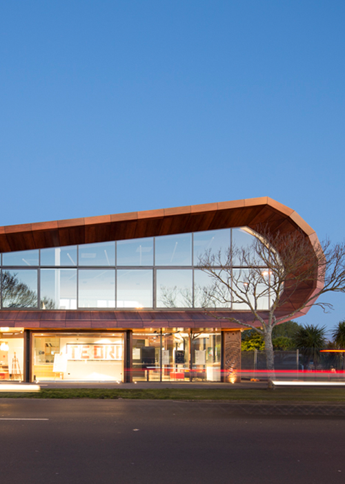 A creatively designed wooden structure with a curved shape and prominent glass windows