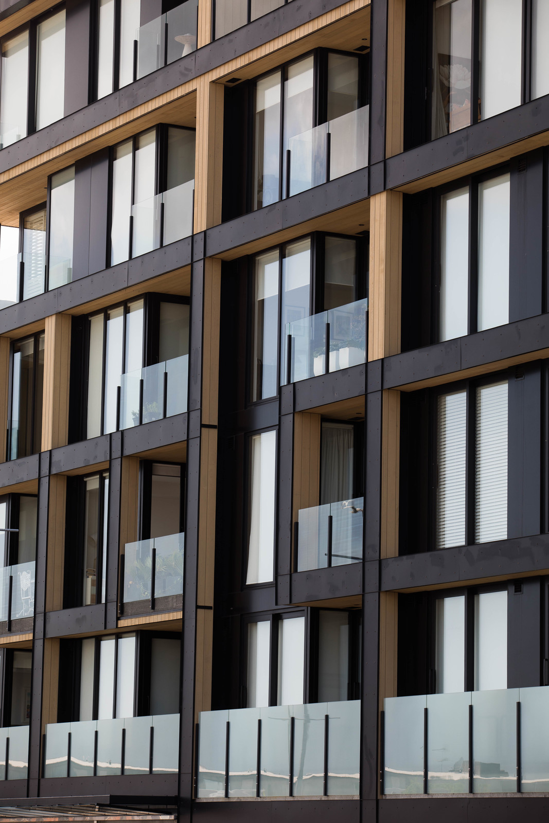 A sleek apartment building featuring numerous glass windows and balustrade