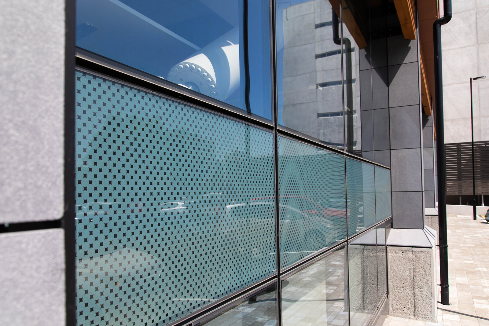 Building facade featuring glass windows with tinted, patterned stripes