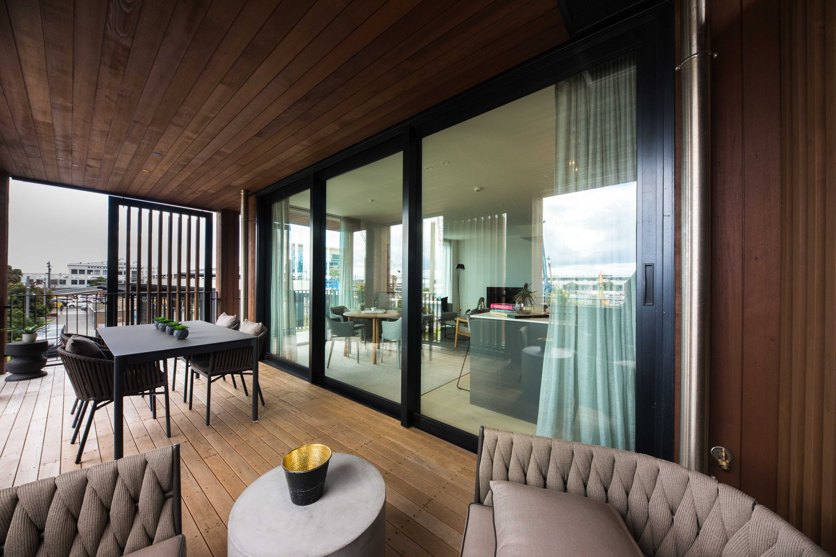 Stylish urban apartments with wooden exterior and deck area, featuring sleek black-framed windows