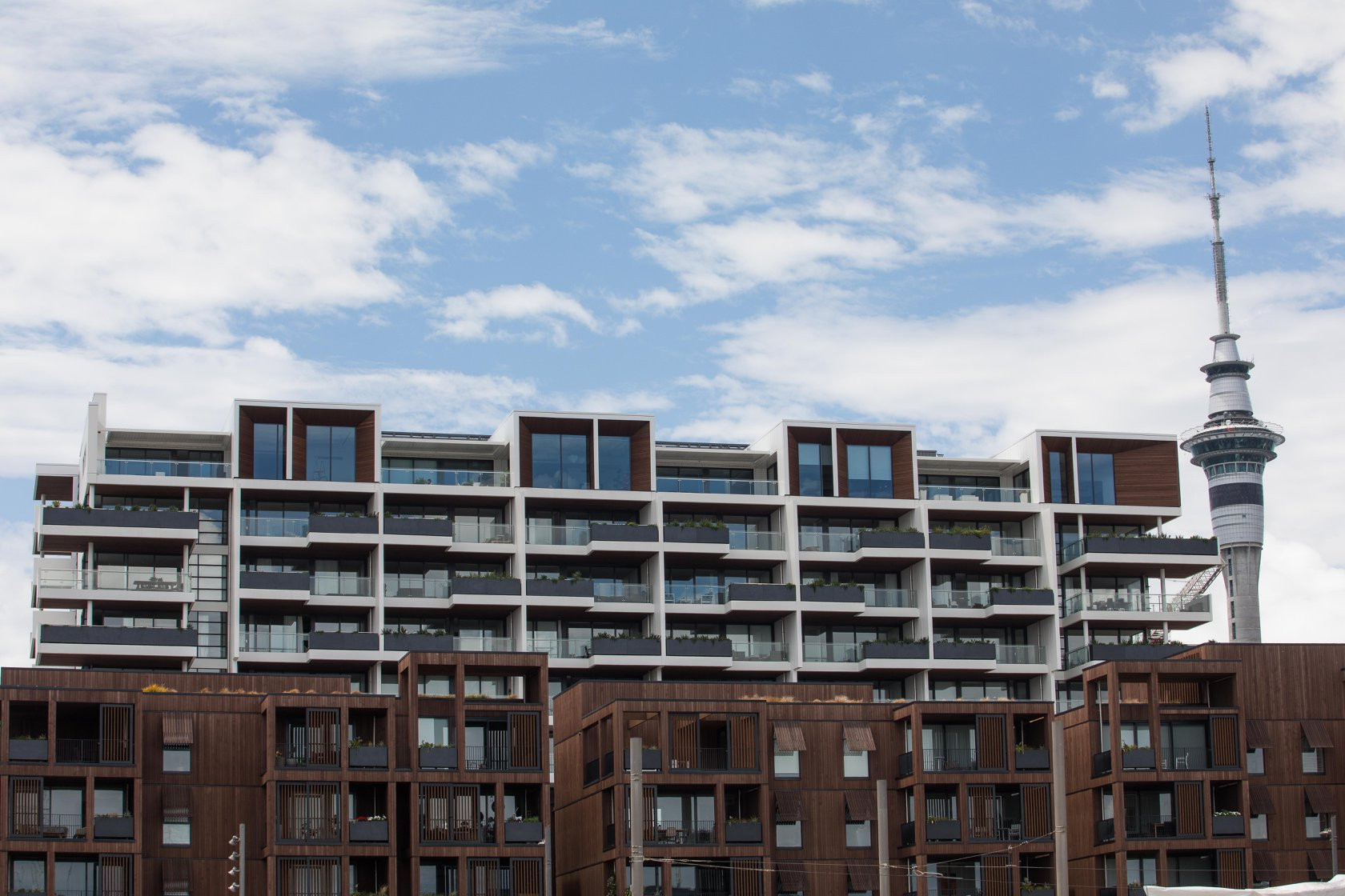 Architectural detail of glass balustrades on balconies of a wood-clad apartment block