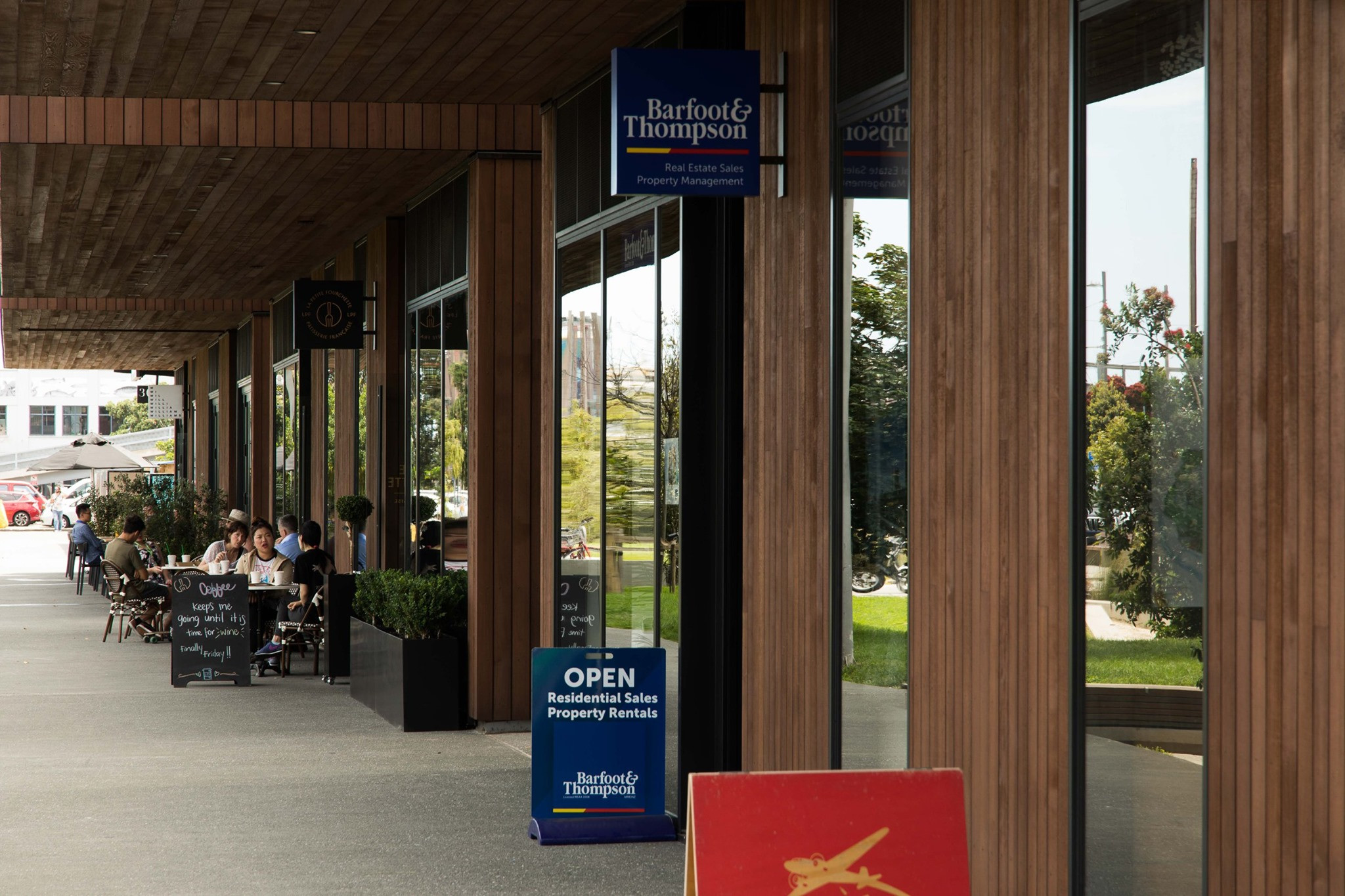 Building with a wooden facade and an outdoor dining cafe setup