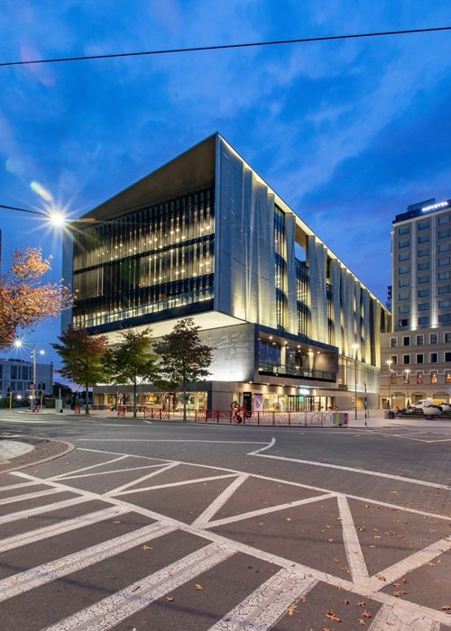 Library with modern design and big windows, illuminated at night with vibrant lights