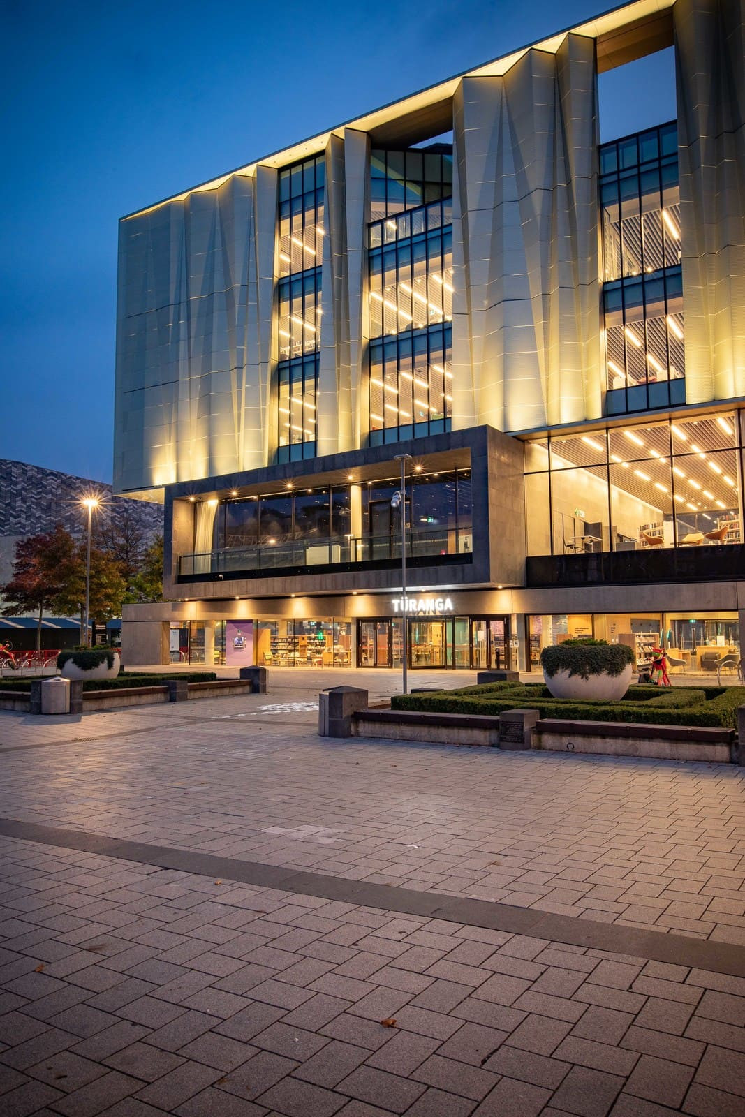 Modern library with large windows, illuminated at night