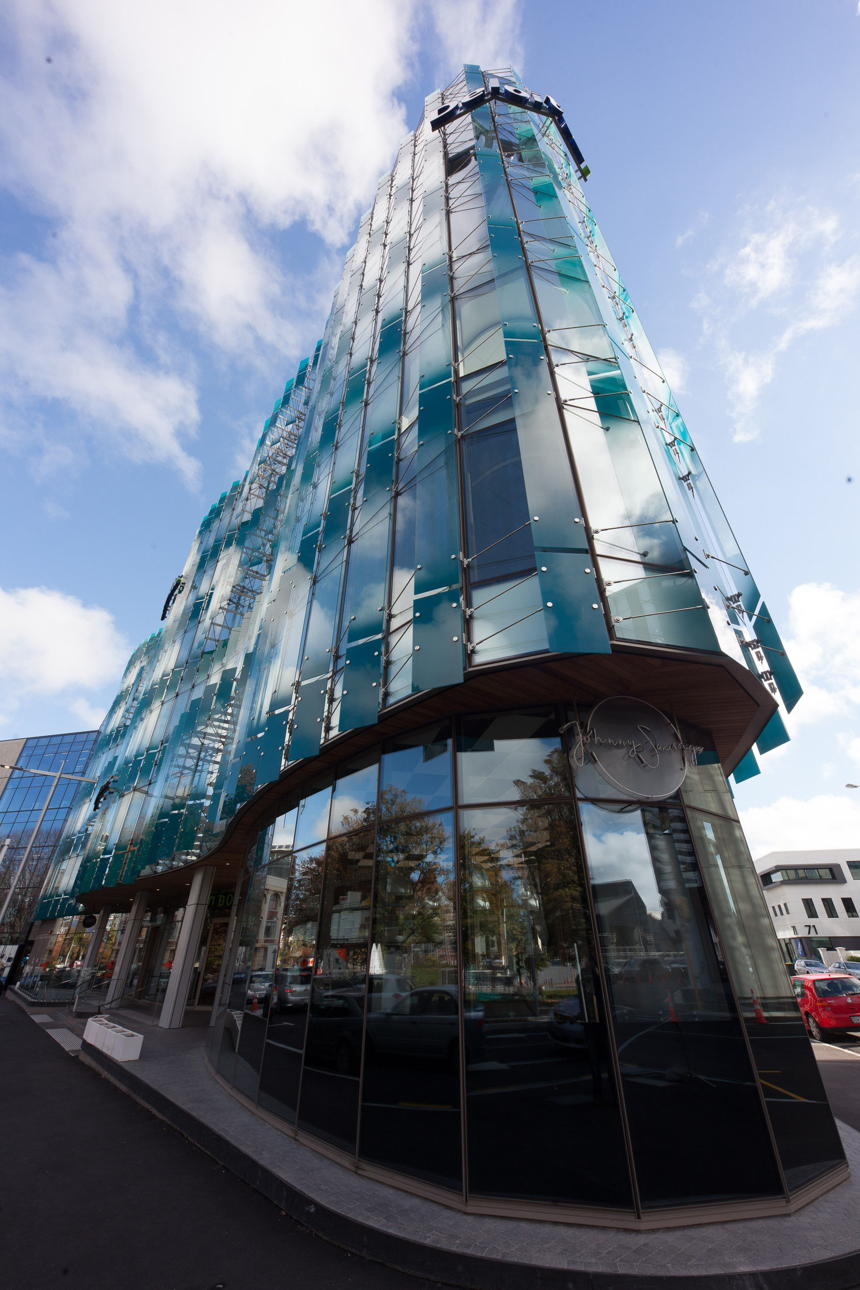 Architectural structure with glass facade and highlighted features with a blue sky