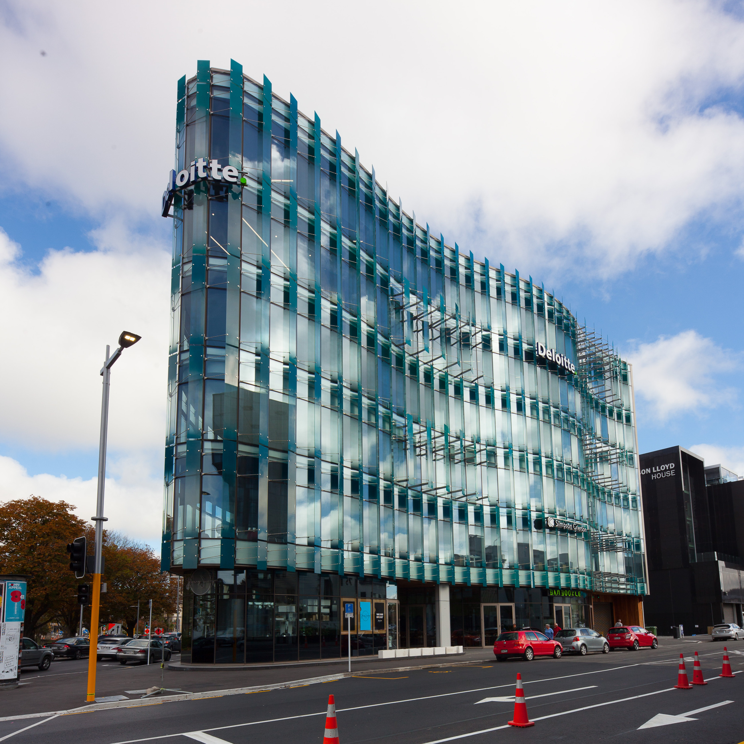 Building showcasing glass windows and highlighted facade, set against a blue sky