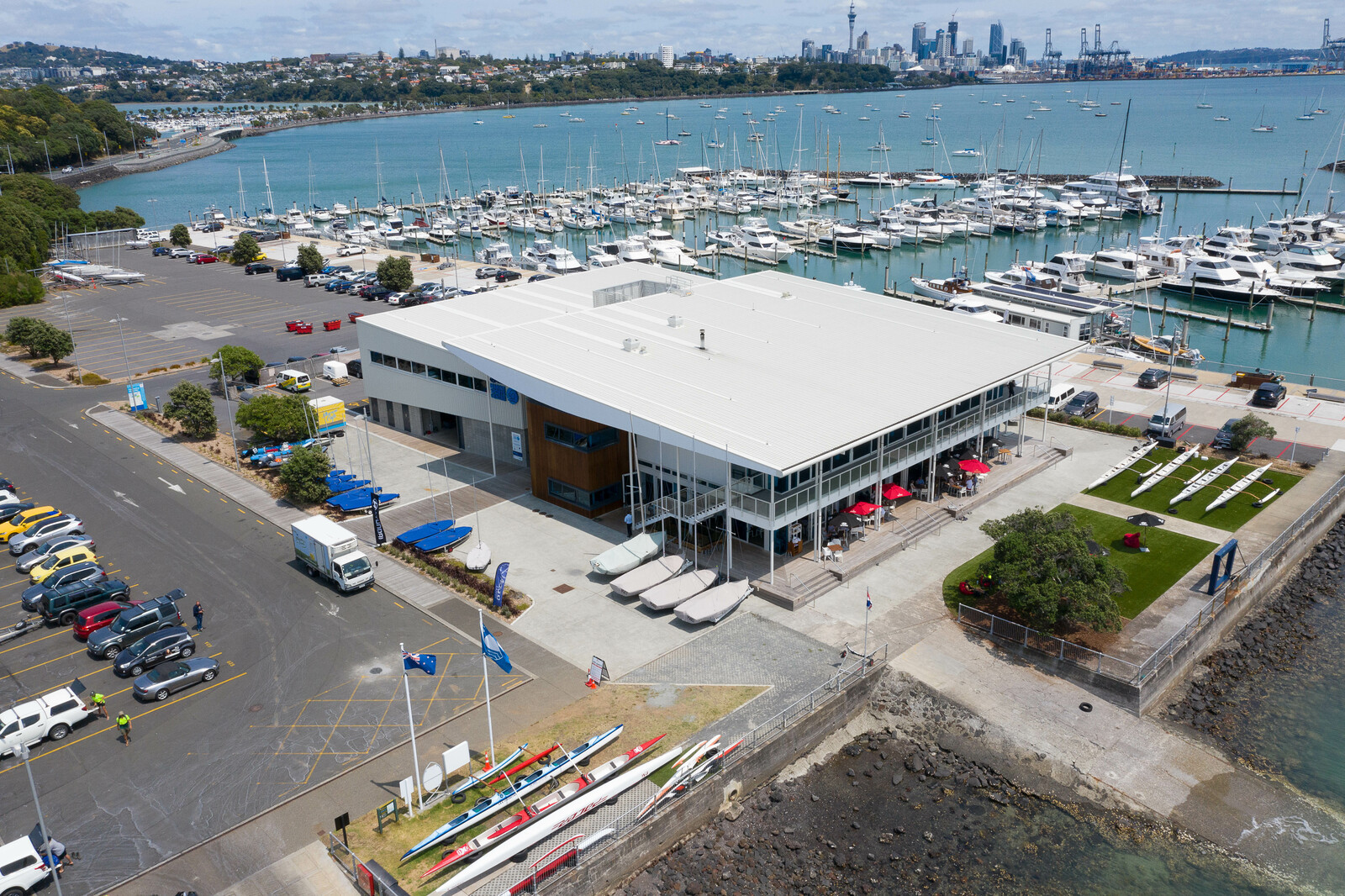 A large building with boats parked in front, overlooking the water