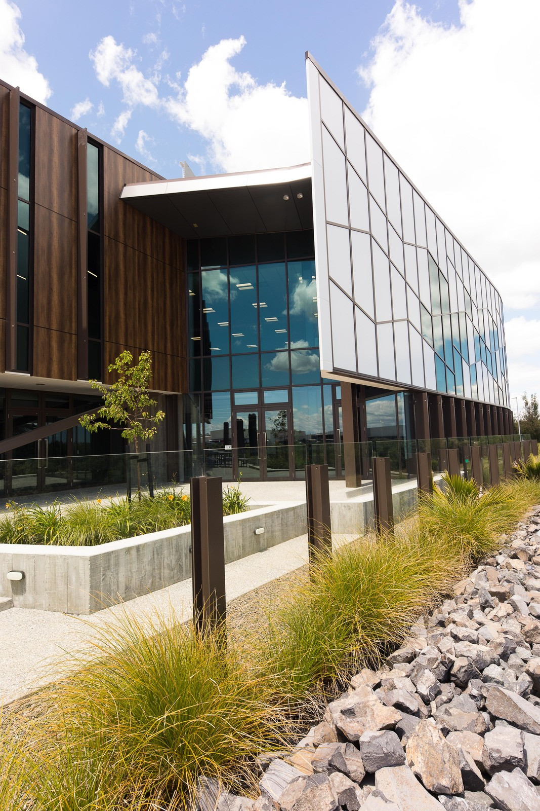 Stylish building featuring patterned glass walls, white panels, and lush greenery