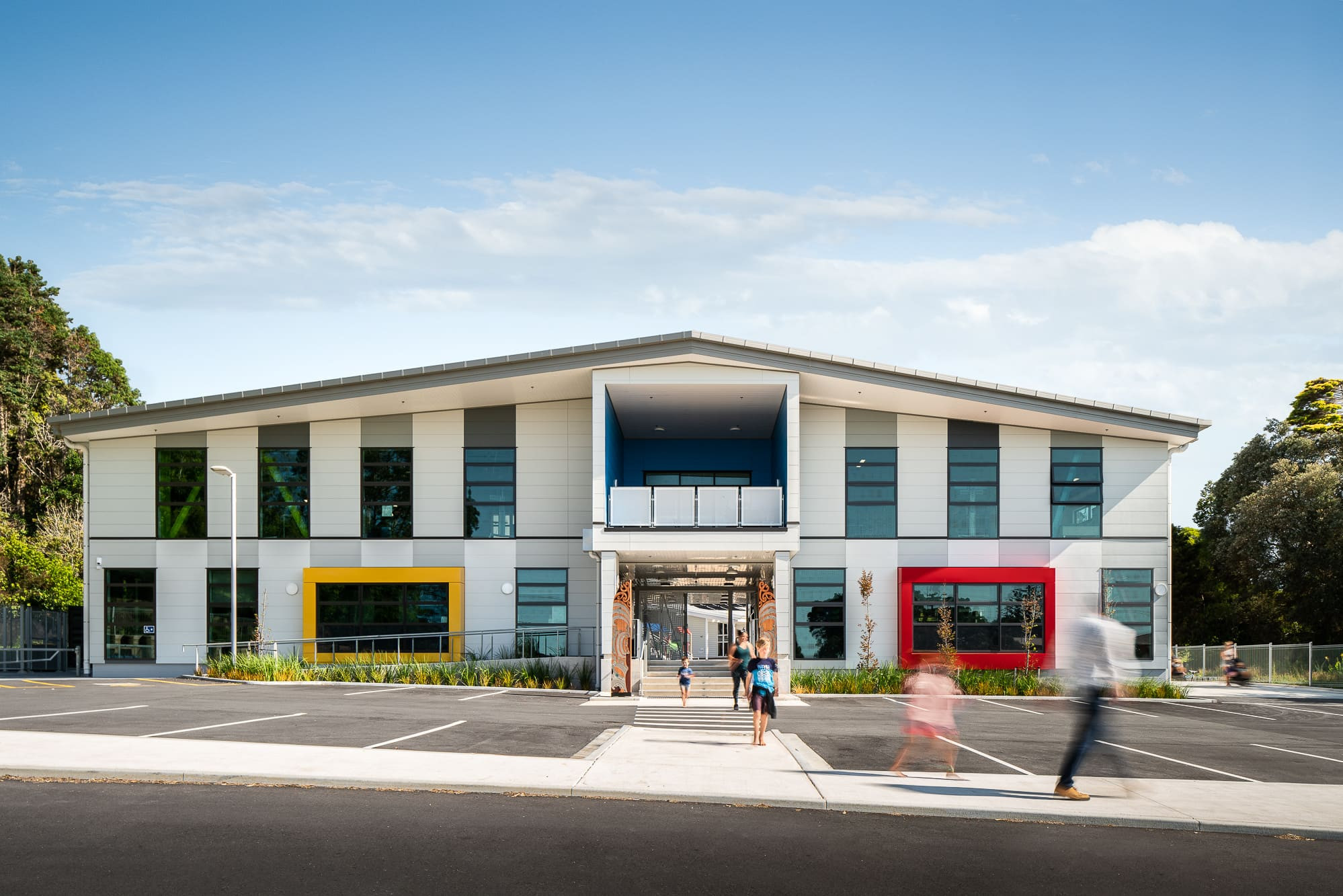 Vibrant building and parking lot at Opope Beach School, with tall windows