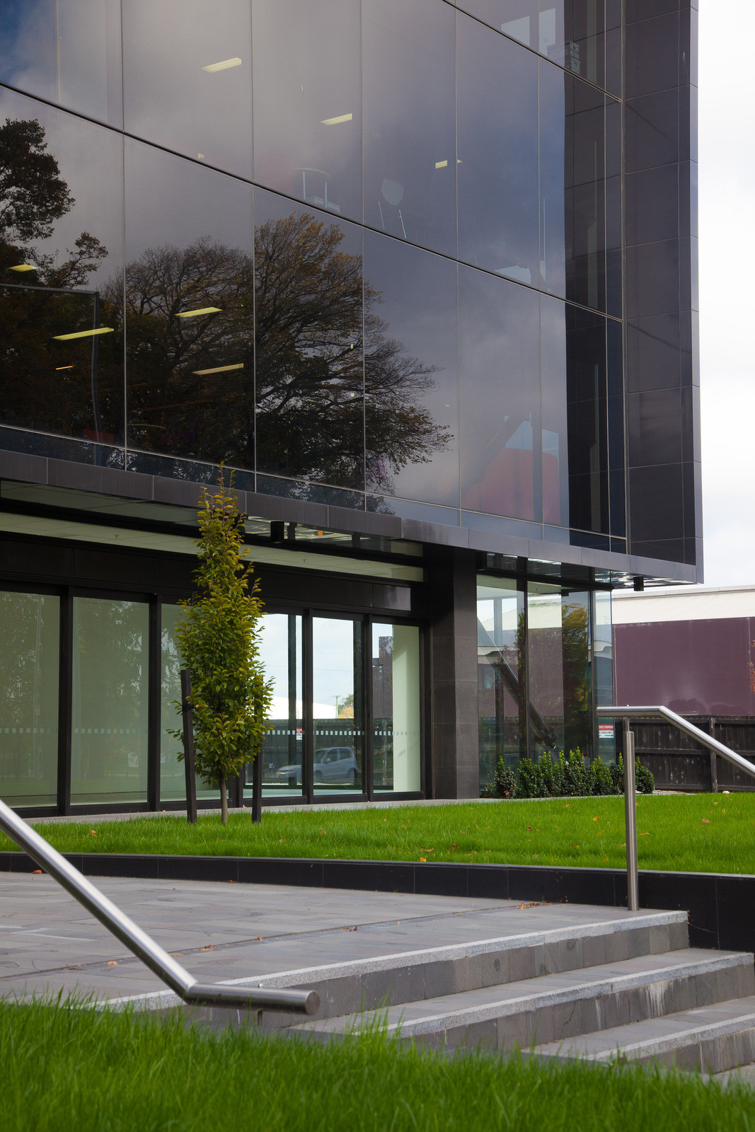 Modern Opus house with dark tinted windows, surrounded by grass