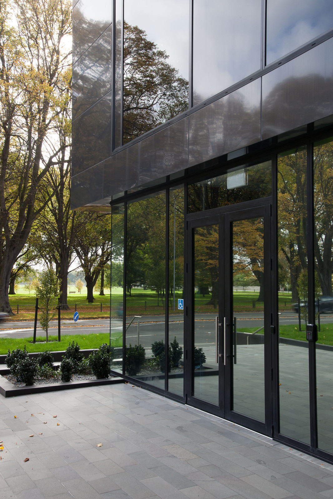 Opus house with dark tinted windows, nestled in lush green grass