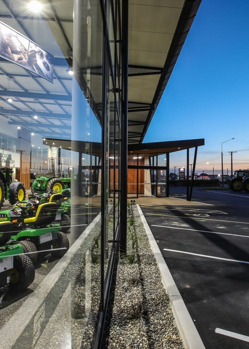 Tractors on display in a well-lit room with big windows