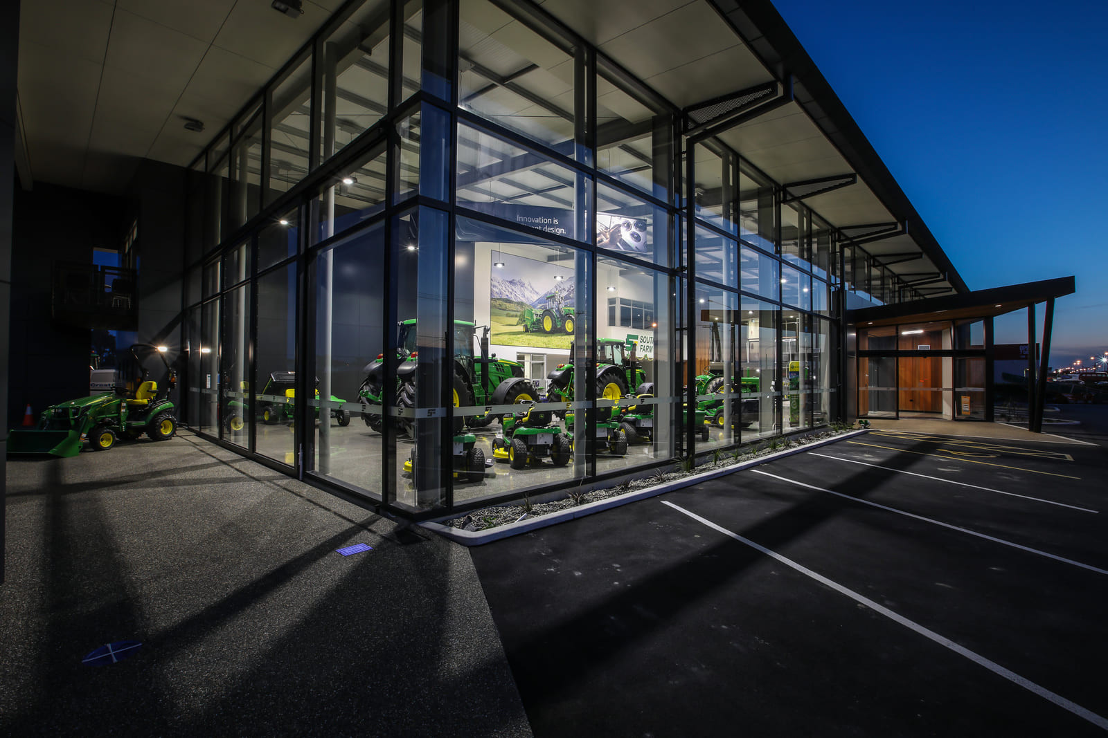 Brightly lit space with large windows featuring tractors