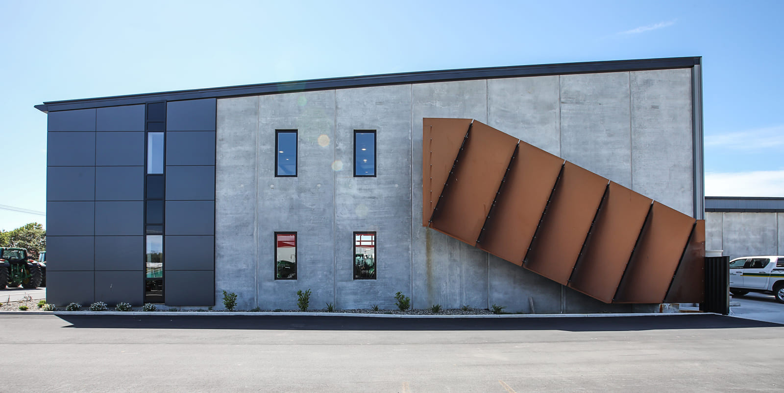 A building with a large metal structure on the side, featuring glass windows