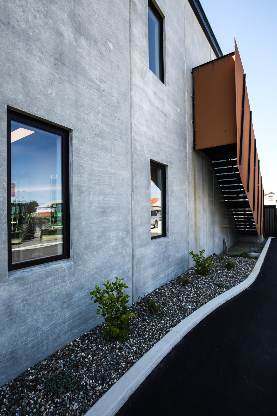 Glass-windowed building with a prominent metal structure on one side