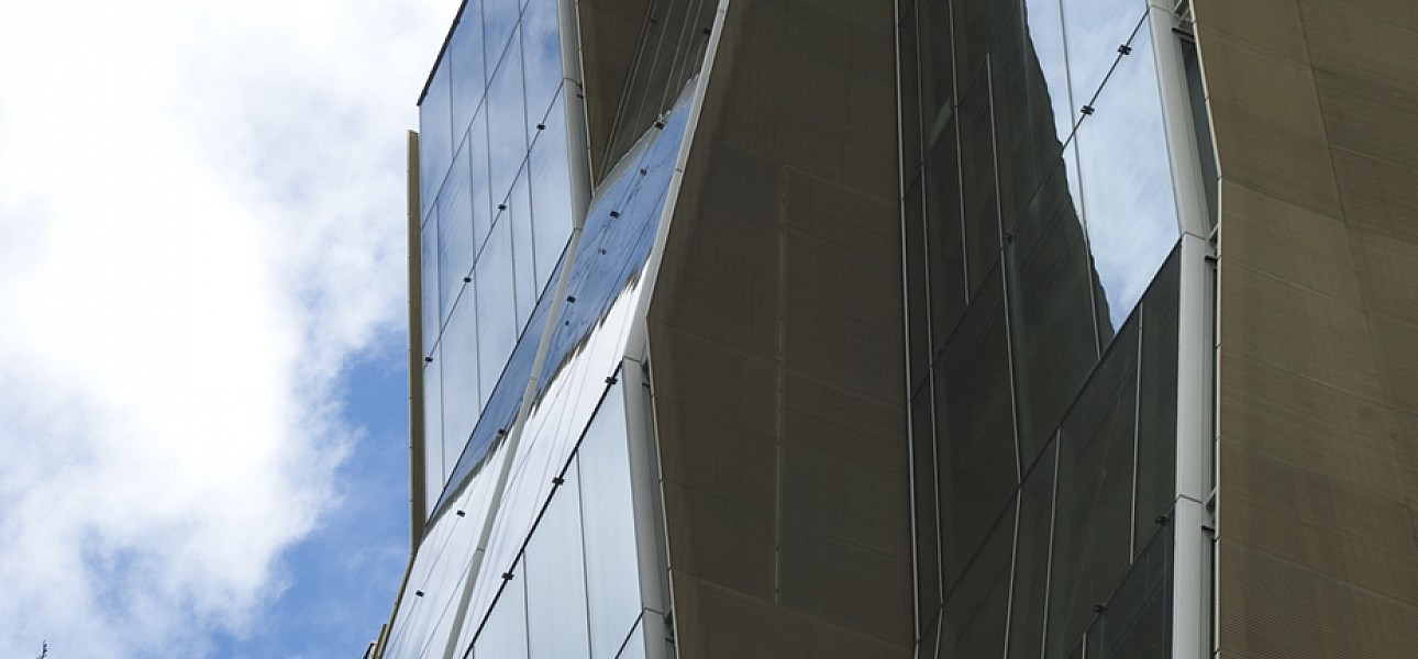 Close up of a tall commercial building with a large glass facade