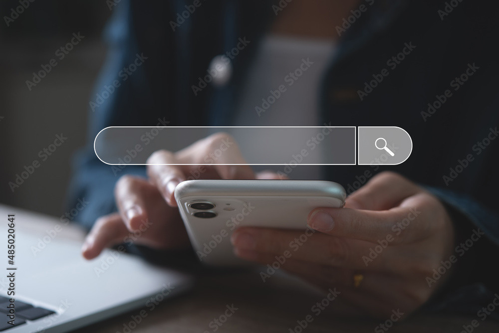 A woman multitasking with a smartphone and laptop, with transparent search bar